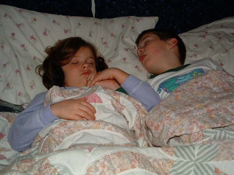 Jo's two children asleep as toddlers, holding hands